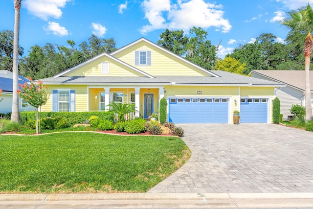 view of front of home featuring a front yard, a porch, and a garage