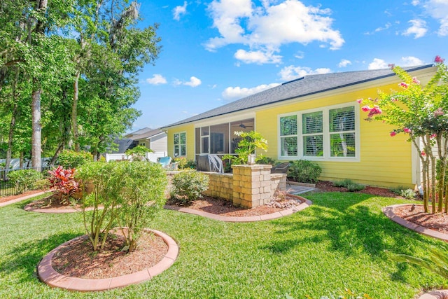 back of property with a yard and a sunroom