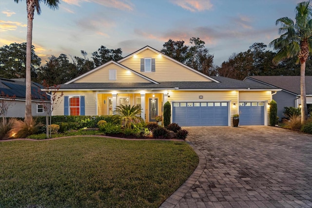 view of front of property featuring a lawn and a garage