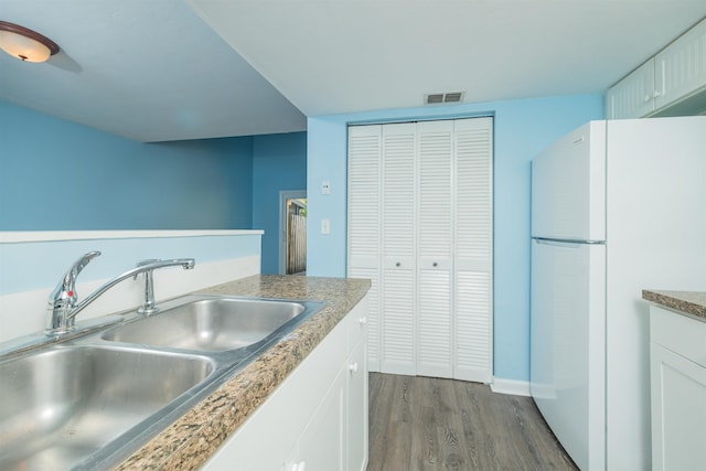 kitchen featuring white cabinets, sink, white fridge, and dark hardwood / wood-style flooring