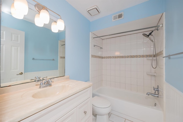 full bathroom featuring tile patterned flooring, tiled shower / bath combo, toilet, and vanity