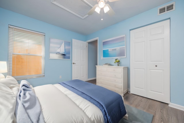 bedroom with a closet, dark hardwood / wood-style floors, and ceiling fan