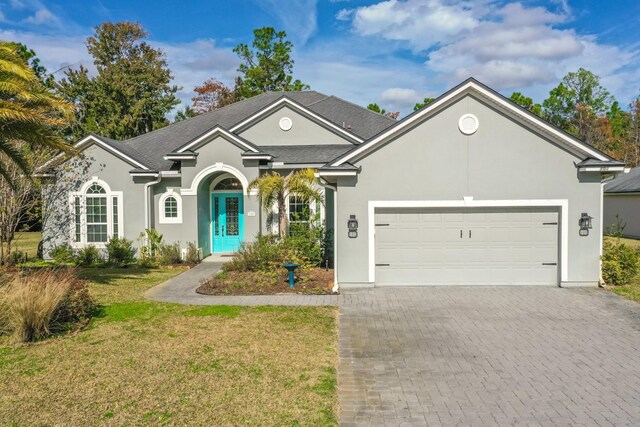 view of front of property with a front yard and a garage