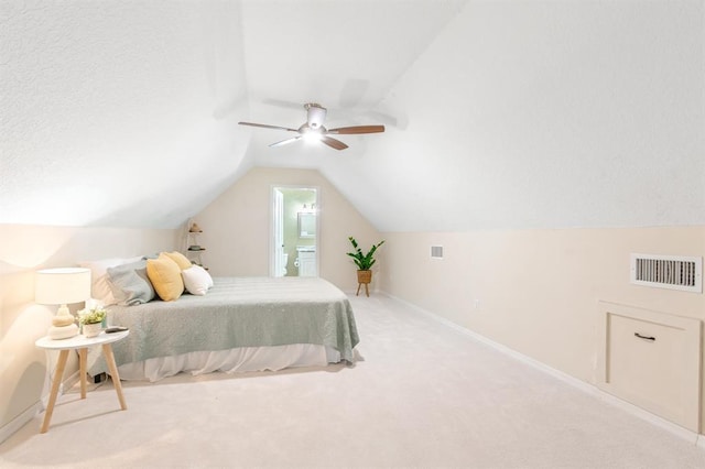 carpeted bedroom with ceiling fan, connected bathroom, and vaulted ceiling