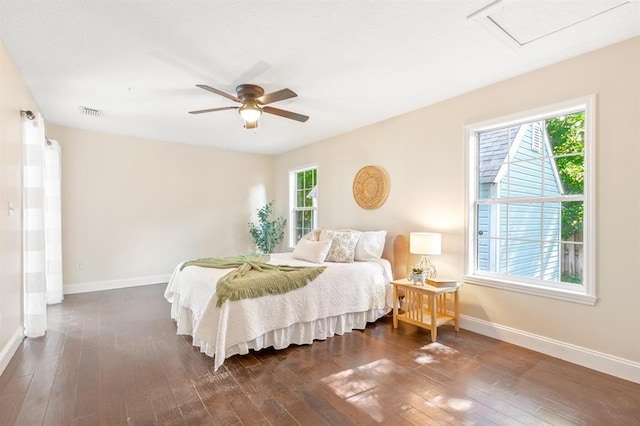 bedroom featuring ceiling fan, dark hardwood / wood-style flooring, and multiple windows