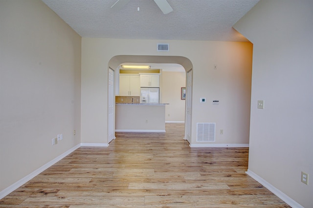 20102 Harbour Vista Cir, Saint Augustine, FL 32080 - empty room featuring arched walkways, ceiling fan, light wood-style floors, and a textured ceiling