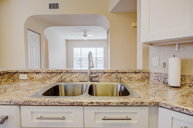 20102 Harbour Vista Cir, Saint Augustine, FL 32080 - kitchen featuring a ceiling fan, white cabinets, arched walkways, and light stone countertops
