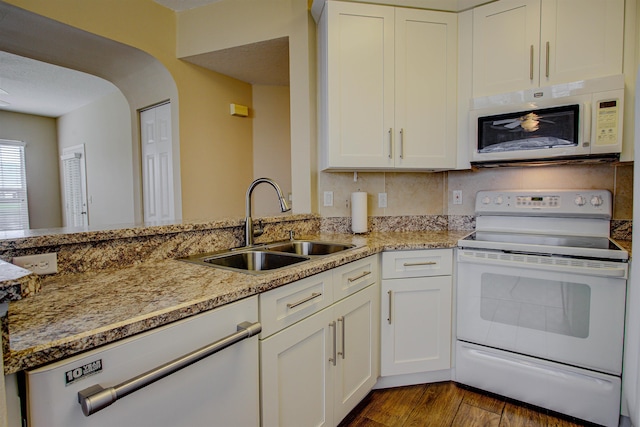 20102 Harbour Vista Cir, Saint Augustine, FL 32080 - kitchen with white appliances, white cabinetry, arched walkways, dark wood-type flooring, and light stone countertops