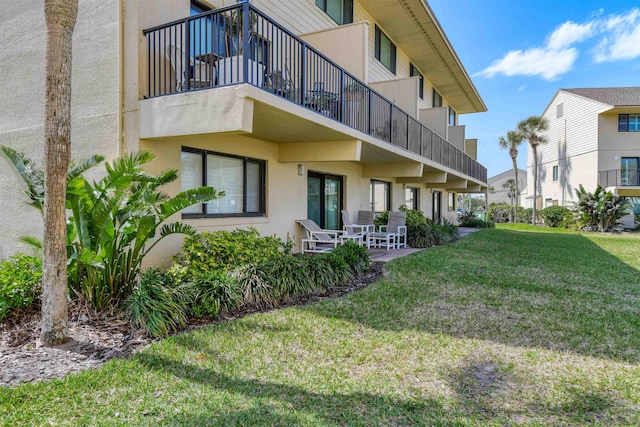 8550 S A1A # 331, Saint Augustine, FL 32080 - rear view of house with a balcony, a lawn, stucco siding, and a patio