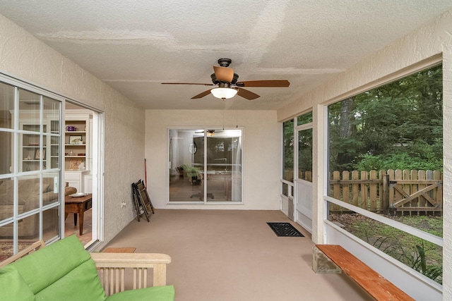 unfurnished sunroom featuring ceiling fan