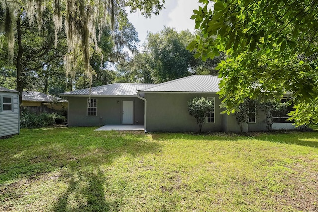 back of property featuring a yard and a patio