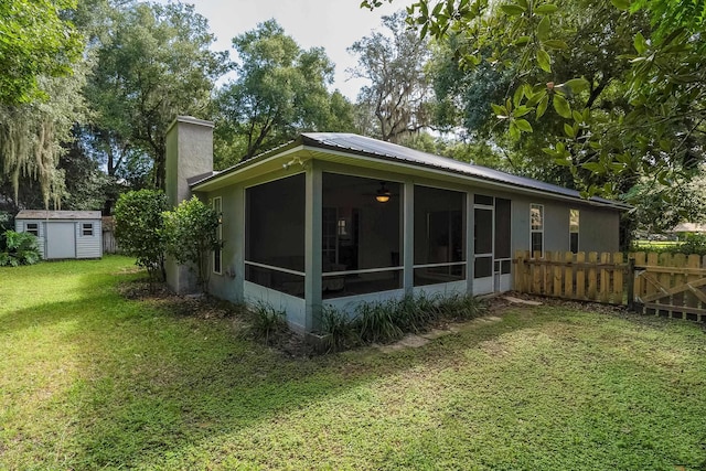 rear view of house featuring a shed and a lawn