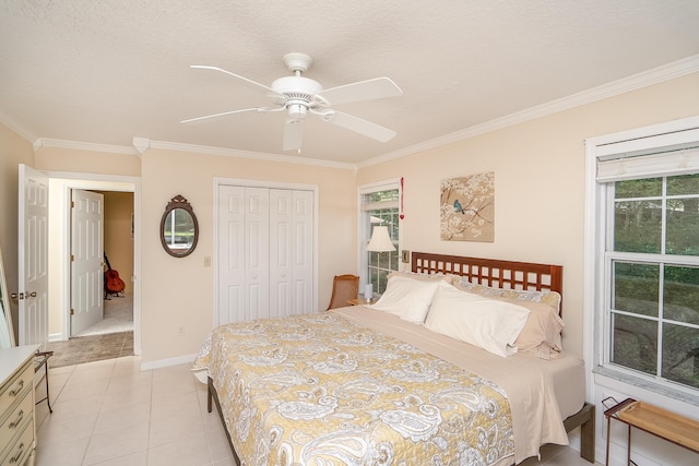 tiled bedroom with ceiling fan, a closet, crown molding, and a textured ceiling