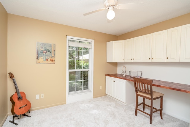 kitchen with light carpet, built in desk, and butcher block counters