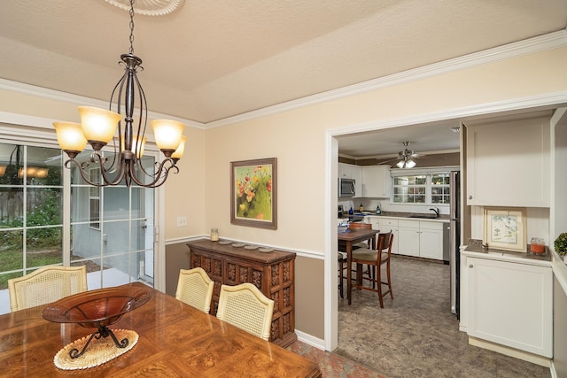 dining area with a textured ceiling, ceiling fan with notable chandelier, ornamental molding, and sink