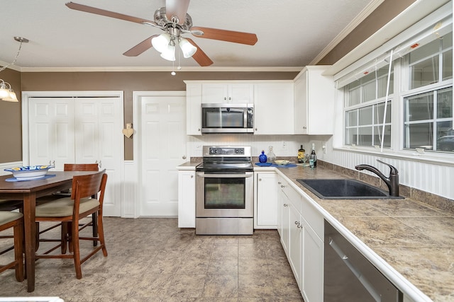 kitchen with crown molding, sink, white cabinets, and appliances with stainless steel finishes