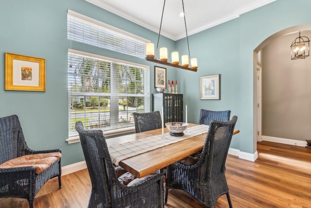 303 S Ocean Trace Rd, Saint Augustine, FL 32080 - dining space featuring a chandelier, arched walkways, baseboards, wood finished floors, and ornamental molding