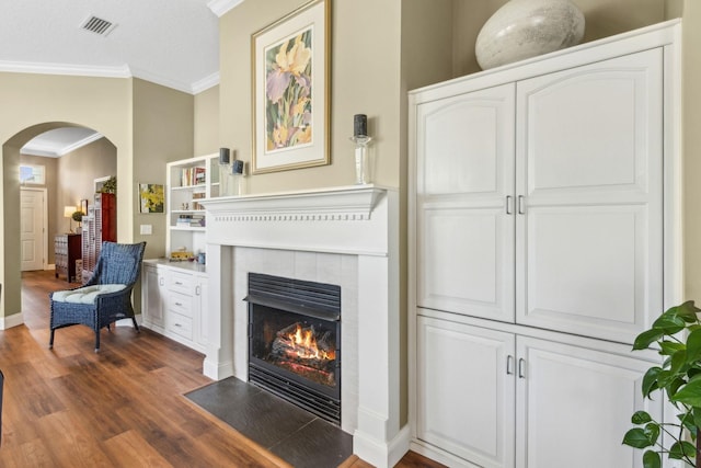 303 S Ocean Trace Rd, Saint Augustine, FL 32080 - living area featuring arched walkways, ornamental molding, wood finished floors, a tile fireplace, and baseboards