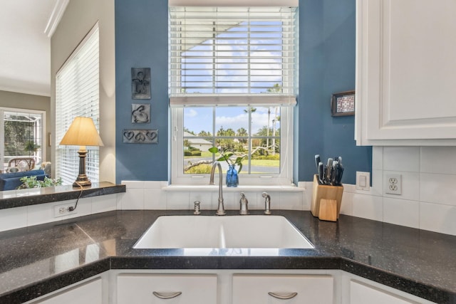 303 S Ocean Trace Rd, Saint Augustine, FL 32080 - kitchen with a sink, white cabinets, crown molding, dark countertops, and tasteful backsplash
