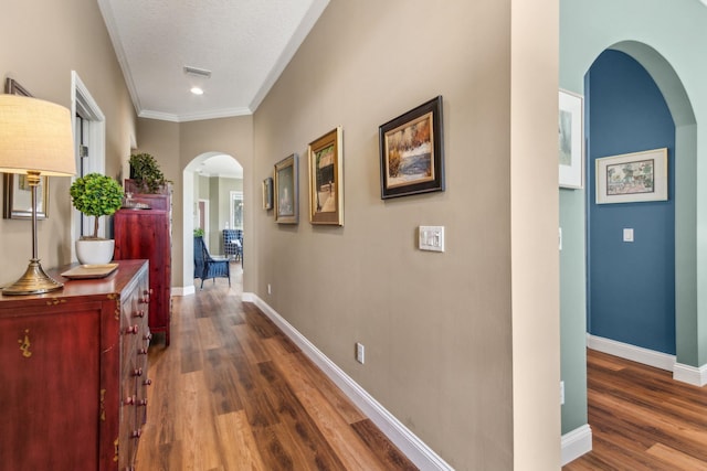 303 S Ocean Trace Rd, Saint Augustine, FL 32080 - hall featuring arched walkways, dark wood-style flooring, baseboards, crown molding, and a textured ceiling
