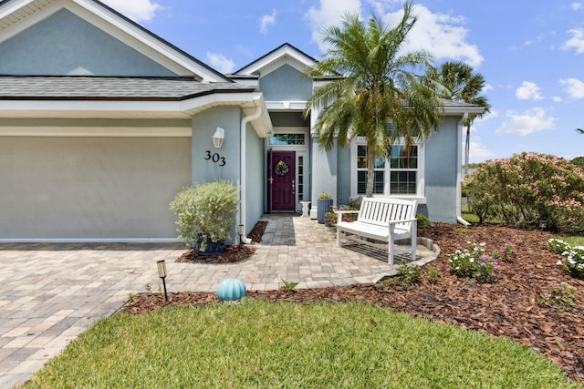 303 S Ocean Trace Rd, Saint Augustine, FL 32080 - ranch-style home with stucco siding, a garage, and decorative driveway