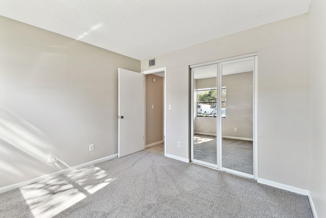 3 Tarragona Ct, Saint Augustine, FL 32086 - unfurnished bedroom featuring a textured ceiling, baseboards, carpet, and a closet