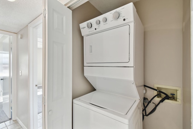 3 Tarragona Ct, Saint Augustine, FL 32086 - washroom featuring stacked washer / dryer, a textured ceiling, and light tile patterned flooring
