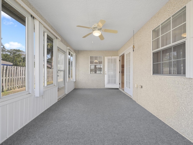 unfurnished sunroom featuring ceiling fan