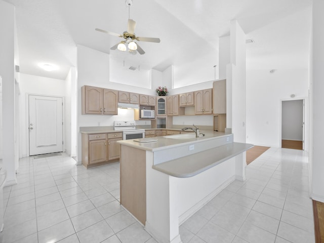 kitchen with a breakfast bar, high vaulted ceiling, sink, kitchen peninsula, and white appliances