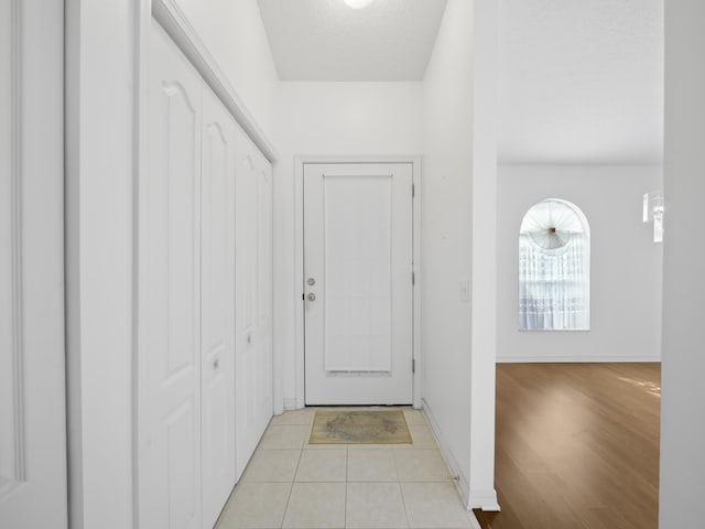 doorway to outside with light tile patterned floors and a textured ceiling