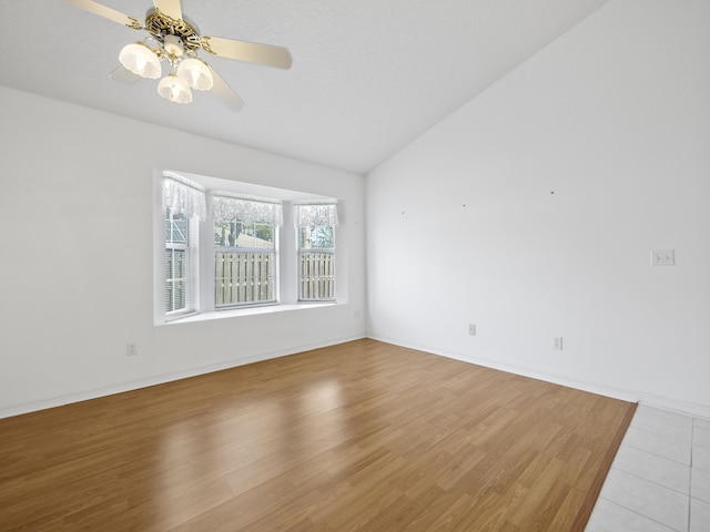 empty room featuring ceiling fan, lofted ceiling, and light hardwood / wood-style floors