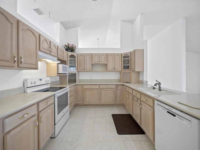 kitchen with sink, white appliances, light tile patterned flooring, and light brown cabinets