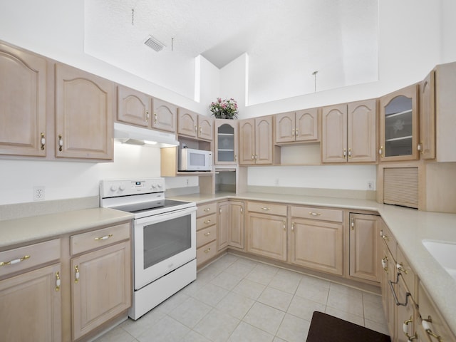 kitchen featuring light tile patterned floors, white appliances, and light brown cabinets