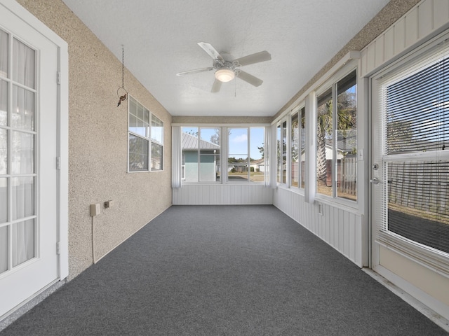 unfurnished sunroom with ceiling fan