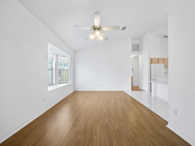 unfurnished room featuring lofted ceiling, ceiling fan, and light hardwood / wood-style flooring