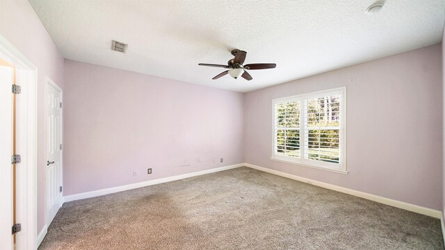 carpeted spare room with ceiling fan and a textured ceiling