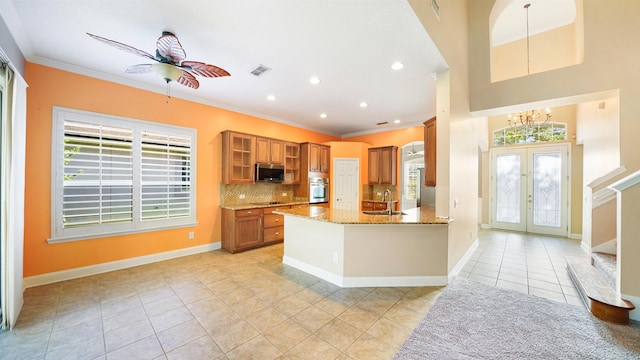 kitchen with french doors, light stone counters, stainless steel appliances, sink, and light tile patterned floors