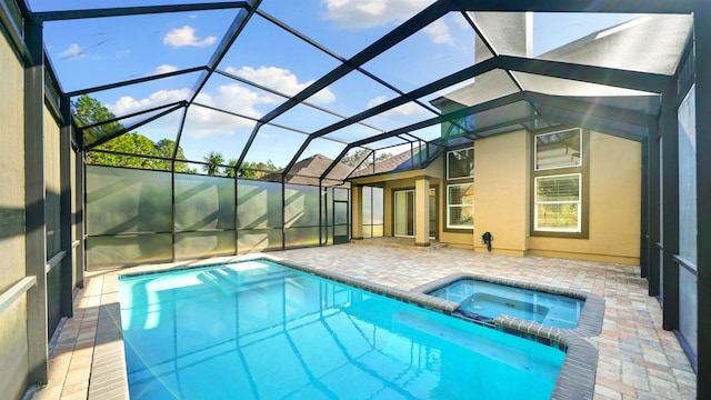 view of pool with a lanai, a patio area, and an in ground hot tub