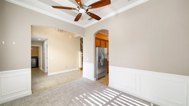 carpeted spare room featuring crown molding and ceiling fan