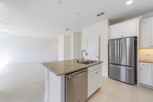 kitchen with appliances with stainless steel finishes, a kitchen island with sink, white cabinetry, and sink