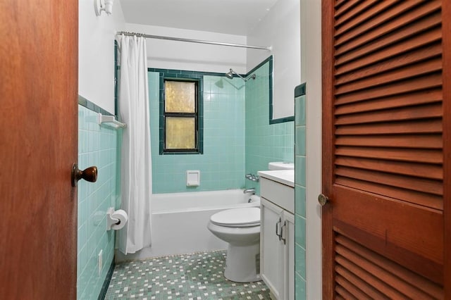 bathroom featuring tile patterned flooring, vanity, shower / bath combination with curtain, toilet, and tile walls