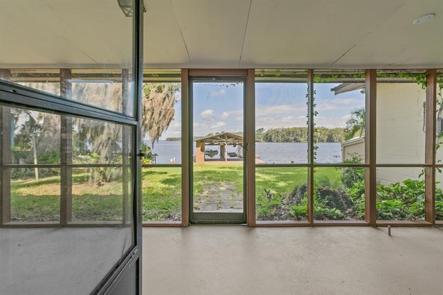 unfurnished sunroom featuring a water view