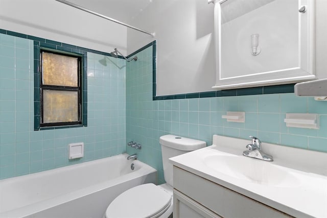 bathroom featuring washtub / shower combination, vanity, toilet, and tile walls