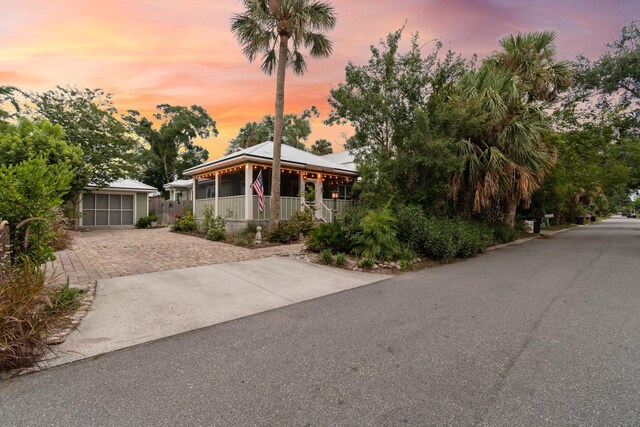 view of front facade featuring a porch, a garage, and an outdoor structure