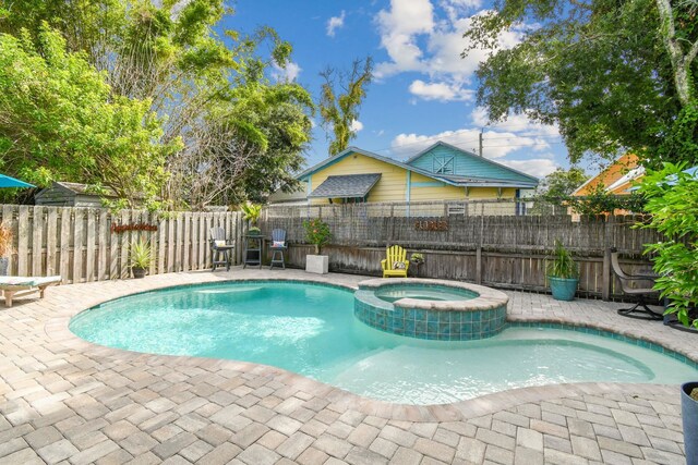 view of swimming pool featuring an in ground hot tub