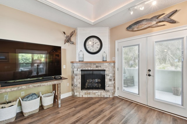 living room featuring hardwood / wood-style floors, a fireplace, a textured ceiling, and french doors