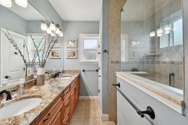 bathroom with tile patterned flooring, vanity, and a tile shower