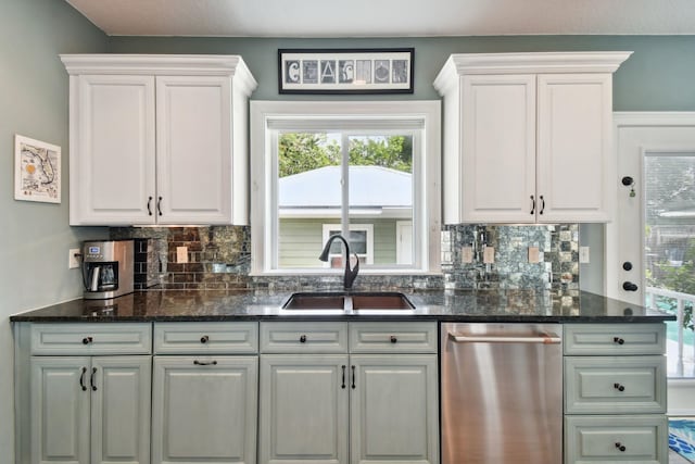 kitchen with white cabinetry, dark stone countertops, and sink