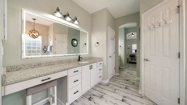 700 N Indigo Ter, Saint Johns, FL 32259 - ensuite bathroom featuring wood finished floors, vanity, a chandelier, baseboards, and a ceiling fan