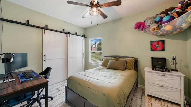 700 N Indigo Ter, Saint Johns, FL 32259 - bedroom featuring a barn door, light wood-style flooring, a desk, and ceiling fan